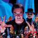 Producer, director, and writer Charles Band stands with some of his horror-movie creations on a crop of the cover of his new memoir.
